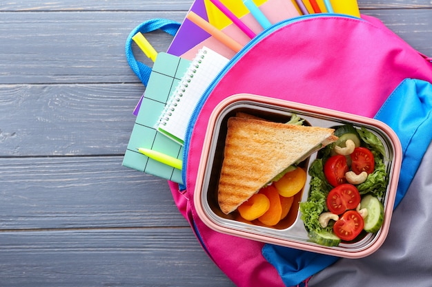 Photo lunch box and schoolbag on wooden