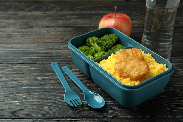 Lunch box and tasty food on wooden background