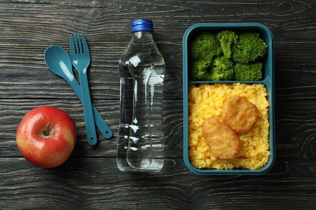 Lunch box and tasty food on wooden background