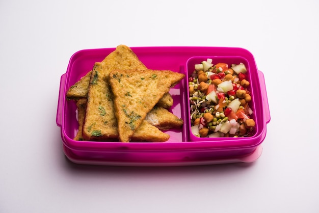 Lunch Box or Tiffin for Indian kids, includes bread Omelette pakora with tomato ketchup or sprouts, selective focus