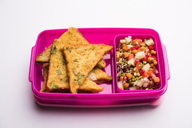 Lunch box o tiffin per bambini indiani, include pane frittata pakora con ketchup o germogli, messa a fuoco selettiva