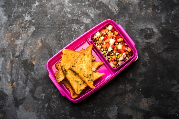 Lunch Box or Tiffin for Indian kids, includes bread Omelette pakora with tomato ketchup or sprouts, selective focus