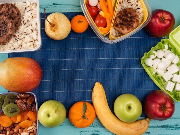 Lunch box with appetizing food and on light wooden table