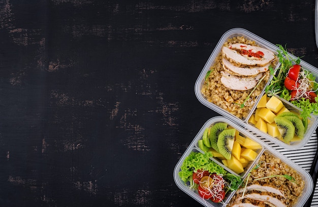 Lunch box with chicken, bulgur, microgreens, tomato and fruit