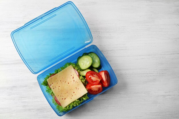 Photo lunch box with food on wooden background top view