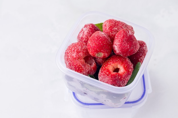 Lunch box with frozen strawberries on a white space. copy space