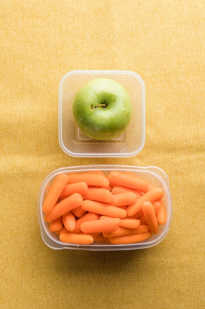 Photo lunch box with healthy snacks plastic container with fruits and vegetables closeup