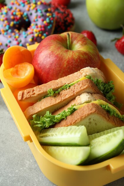 Lunch box con cibo gustoso su sfondo grigio strutturato