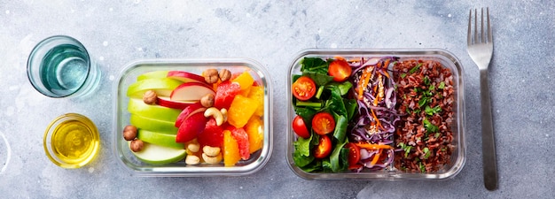 照片饭盒与糙米蔬菜和水果沙拉健康饮食灰色背景顶视图