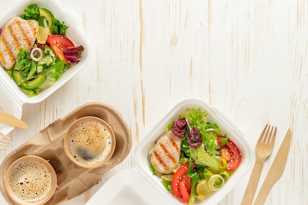 Lunch boxes and coffee on white wooden background. Food delivery, top view, copy space.