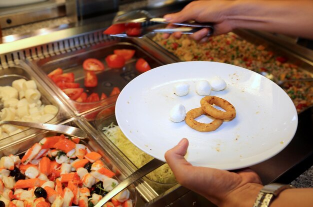 Lunch break that takes tomatoes at the restaurant while in the plate there are rings of onion