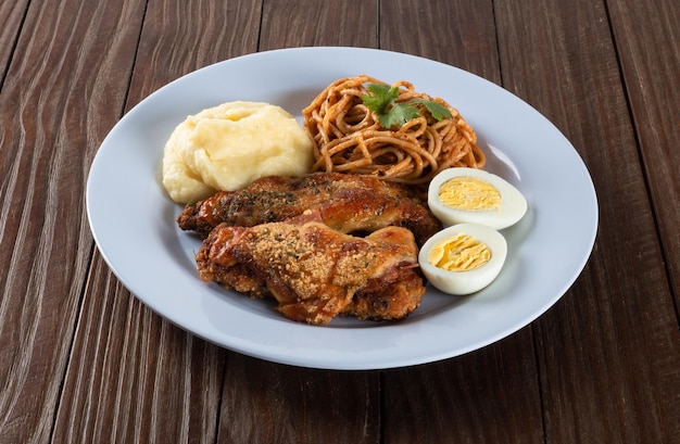 Lunch eten plaat Pasta met geroosterde kip fijngestampt en eieren houten achtergrond