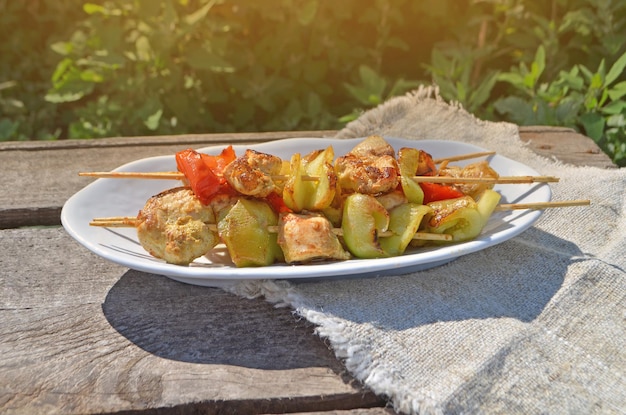 ランチグリルチキンと野菜の串焼き緑のテーブルクロスに白いプレート