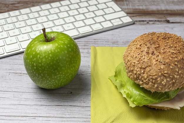 Lunch op de werkplek gezonde sandwich in de buurt van laptop op werktafel. Thuisvoedsel voor kantoorconcept