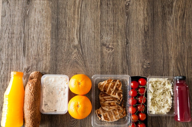 Lunch packed in different boxes. Fresh and healthy eating on wooden background