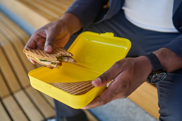 Lunch time. A dark-skinned maneating snadwich with a big appetite