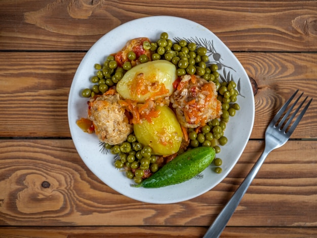 チキンミートボールとご飯と野菜のランチとグリーンピースの缶詰テーブルフォークの上面図