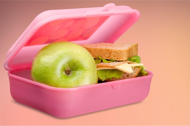 Lunchbox met een appel en broodje op tafel