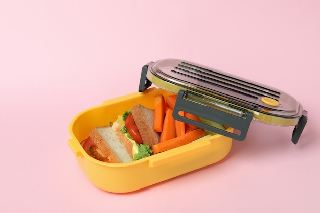 Lunchbox met lekker eten op roze achtergrond