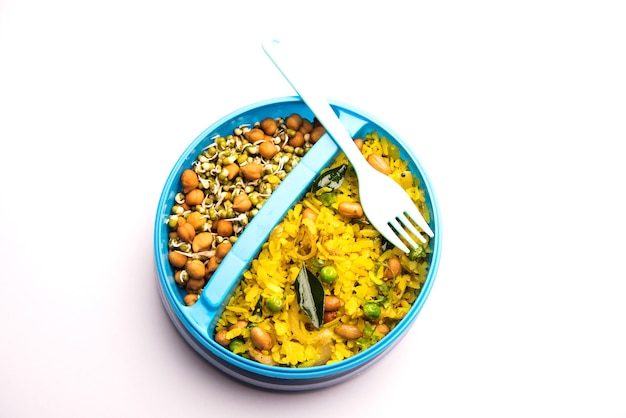 Lunchbox of Tiffin voor Indiase kinderen, hete Poha gemaakt van geklopte rijst en kruiden, vergezeld van spruitjes