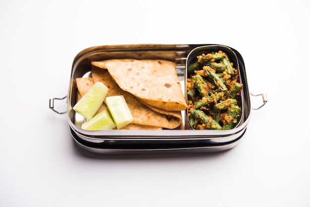 Lunchbox of Tiffin voor Indiase kinderen, inclusief bonen, plantaardige sabzi met roti of chapati, selectieve focus