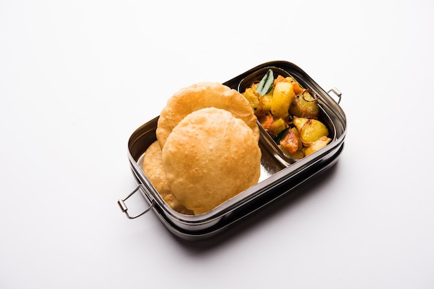 Lunchbox of tiffin voor indiase kinderen, inclusief warme poori, puri met aardappel, aloo sabzi, selectieve focus