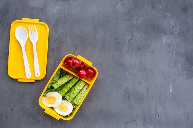 Lunchbox with healthy food on gray 