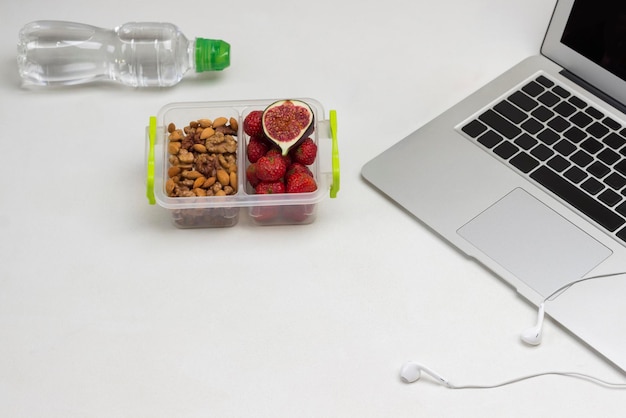 Lunchbox with nuts and fruits Bottle of water Launch Box White background Copy space Flat lay