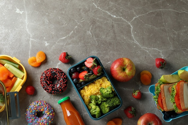 Lunchboxen met lekker eten op grijze getextureerde tafel