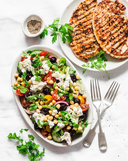 Lunchtafel in mediterrane stijl Griekse kikkererwtensalade en karbonades op lichte achtergrond bovenaanzicht