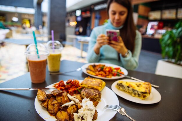 Lunchtime in cafe blurred woman on background into her phone lifestyle