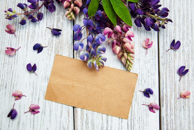 Lupine flowers with vintage card on a  table