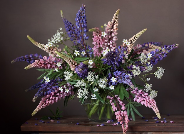 Lupines in een transparante vaas. Stilleven met een boeket van tuin gecultiveerde bloemen.