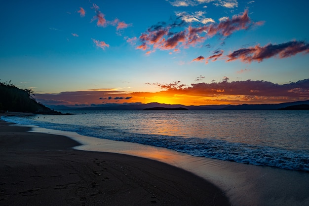 I colori lussureggianti del tramonto sulla spiaggia di ponta do sambaqui