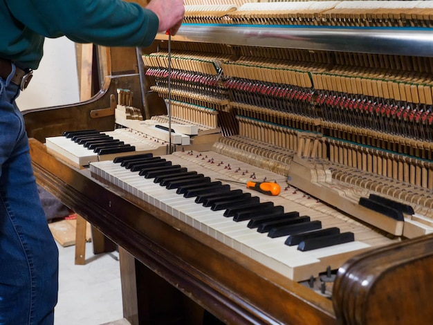 Luthier repairing piano hands making change of piano strings