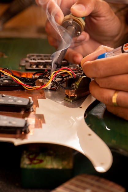 Luthier soldering a guitar wire in his workshop