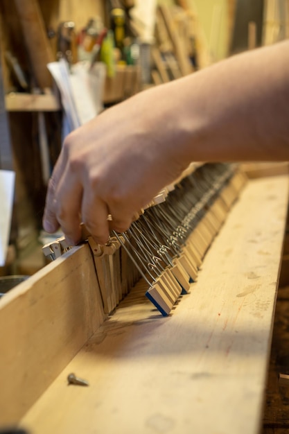 Luthier working on the restoration of a piano Repairing a wooden piano