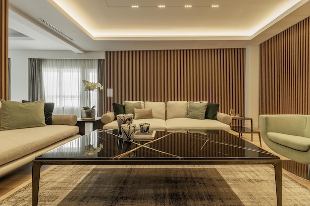 Luxe design woonkamer grote salontafel in zwart marmer hout aan de muren bijpassende vloerkleden en fauteuils met kussens