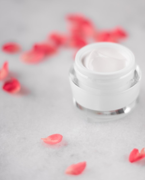 Luxe face cream and rose petals cosmetics with flowers styled beauty concept