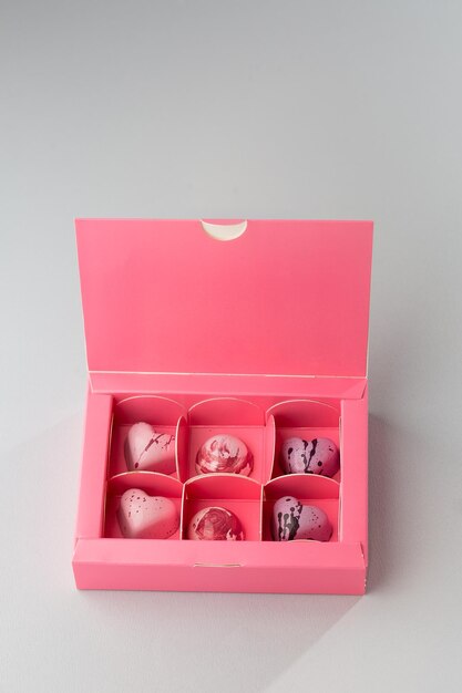 Luxe handgemaakte chocolade snoep in roze doos geïsoleerd op witte achtergrond Exclusieve handgemaakte bonbon Product reclame concept voor patisserie