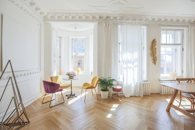 Luxe interieur van een ruim appartement in een oud 19e eeuws historisch huis met modern meubilair. hoog plafond en muren zijn versierd met stucwerk