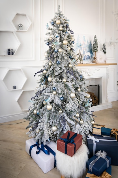 Luxe interieur van woonkamer met versierde kerstboom en geschenken op de houten vloer.