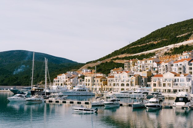 Luxe jachten liggen op een rij afgemeerd aan de lustica baai marina montenegro