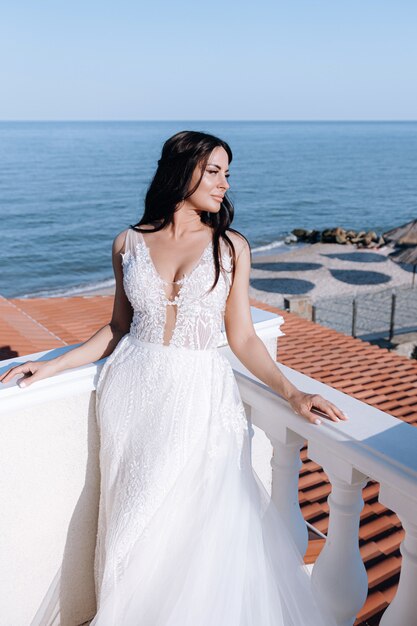 Luxe jonge bruid in een dure modieuze garderobe poseert voor een huwelijksfotoshoot in een luxe vakantieoord