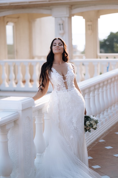 Luxe jonge bruid in een dure modieuze garderobe poseert voor een huwelijksfotoshoot in een luxe vakantieoord