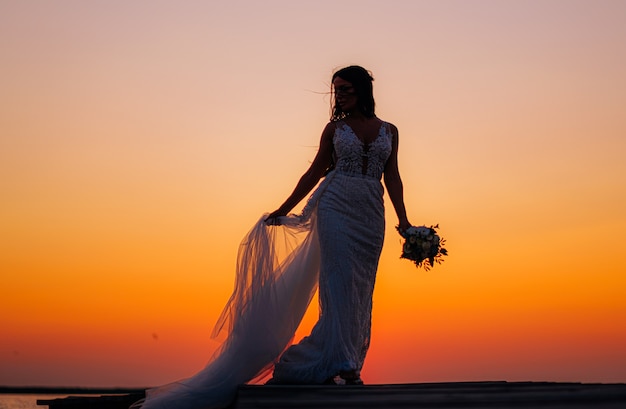 Luxe jonge bruid in een dure modieuze garderobe poseert voor een huwelijksfotoshoot in een luxe vakantieoord