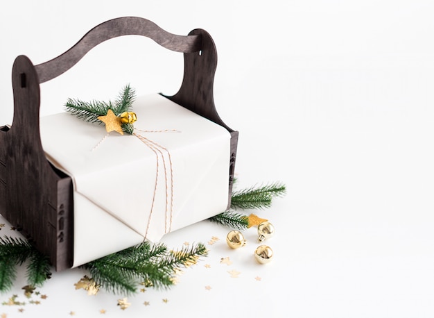 Luxe Nieuwjaarsgeschenk met gouden decoratie en boomtakken. Kerstcadeau in houten mandje. Kerstmisachtergrond met giftdoos. Presenteert voor kerstviering.