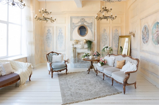 Luxe rijke woonkamer interieur in beige pastelkleur met antieke dure meubels in barokke stijl. muren versierd met stucwerk en fresco's