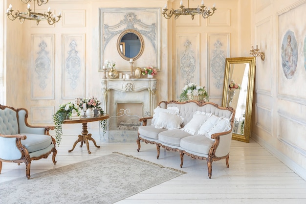 Luxe rijke woonkamer interieur in beige pastelkleur met antieke dure meubels in barokke stijl. muren versierd met stucwerk en fresco's