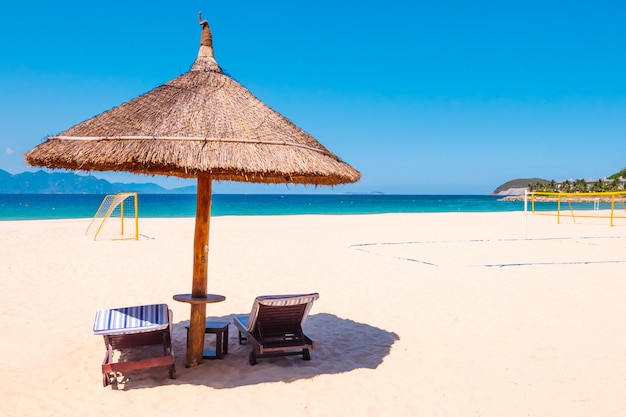 Luxe strand vlakbij hotel. Stoelen en parasol op het strand